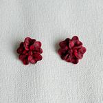 Pair of red floral earrings on a light gray background