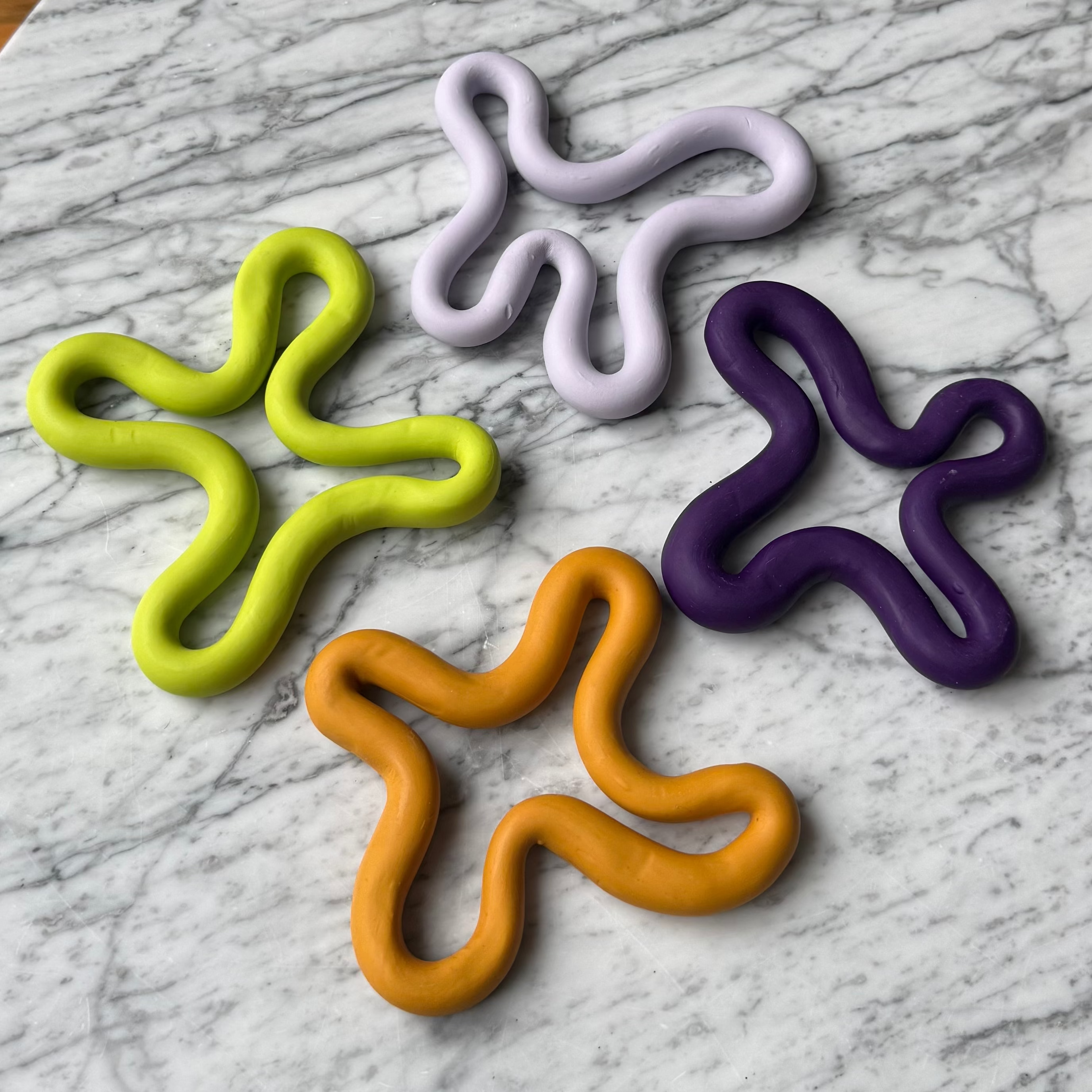 Four colorful star-shaped objects on a marble surface